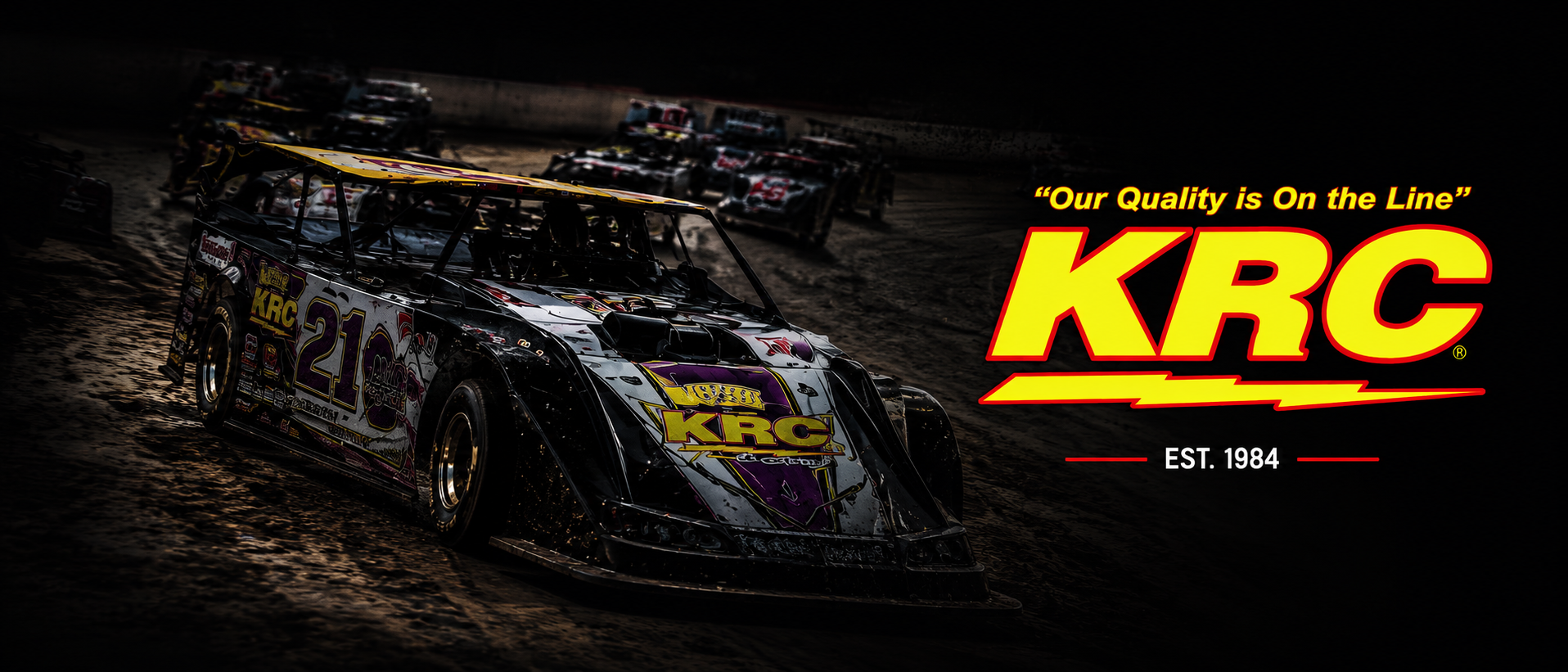 Racing cars on a dirt track with KRC logo and text 'Our Quality is On the Line' on a dark background.